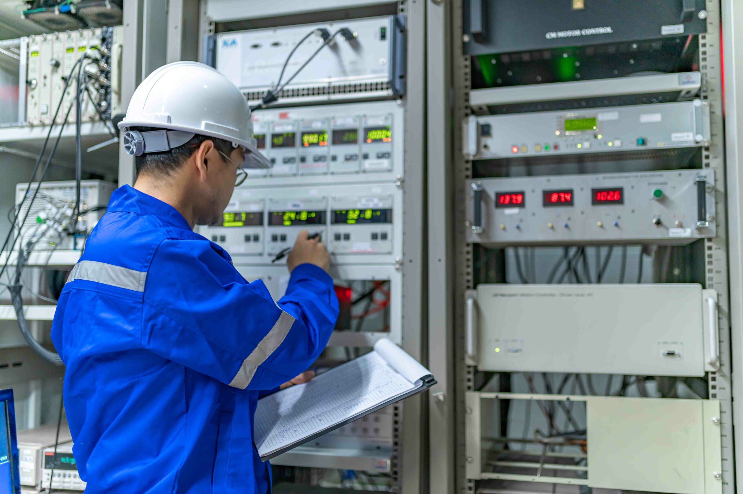 Elektroingenieurin bei der Überprüfung der Spannung am Stromverteilerschrank im Betriebs Kontrollraum.